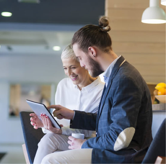 two people sitting looking at tablet